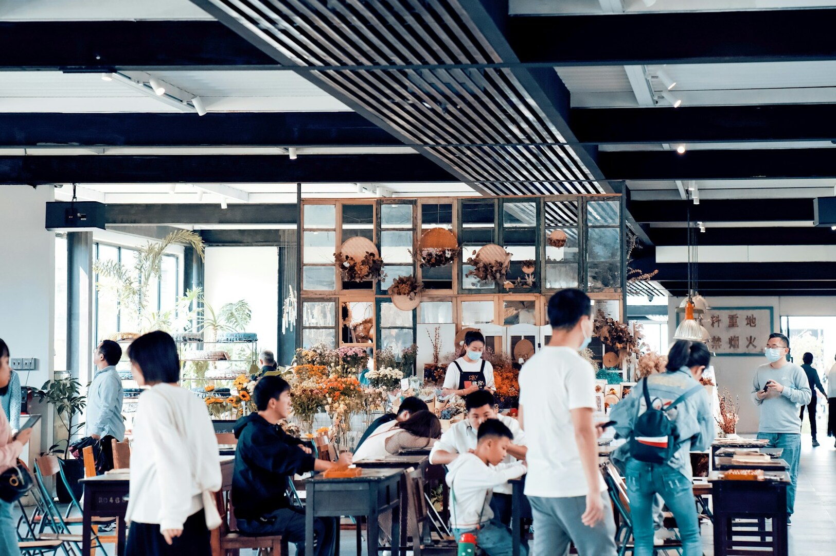 A group of diners seated at tables in a bustling Singapore food court, enjoying their meals and socializing.