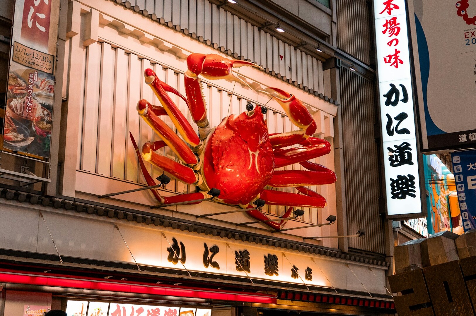 A vibrant red crab showcased in front of a Michelin star restaurant in Japan.
