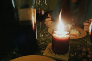 A warm candlelight illuminates a table set with wine and food pairings, perfect for a refined dining occasion.