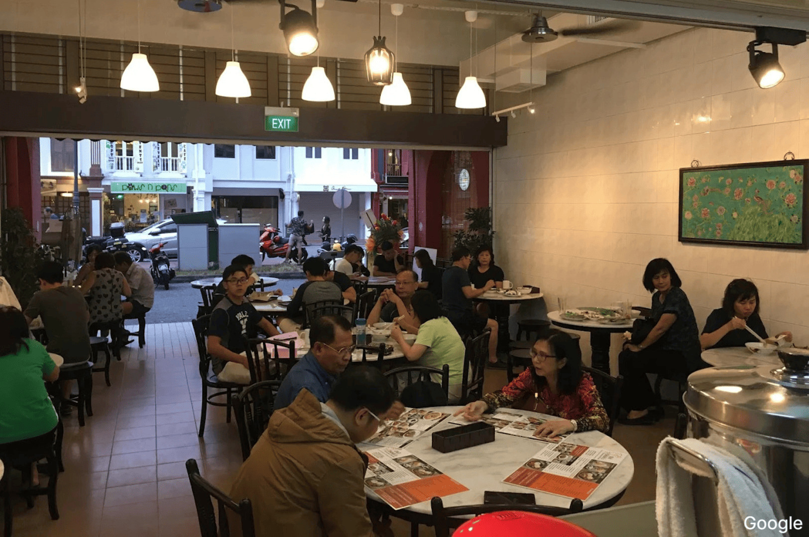 Inside Old Bibik's Peranakan Kitchen, numerous patrons are seated at tables, creating a lively dining atmosphere.