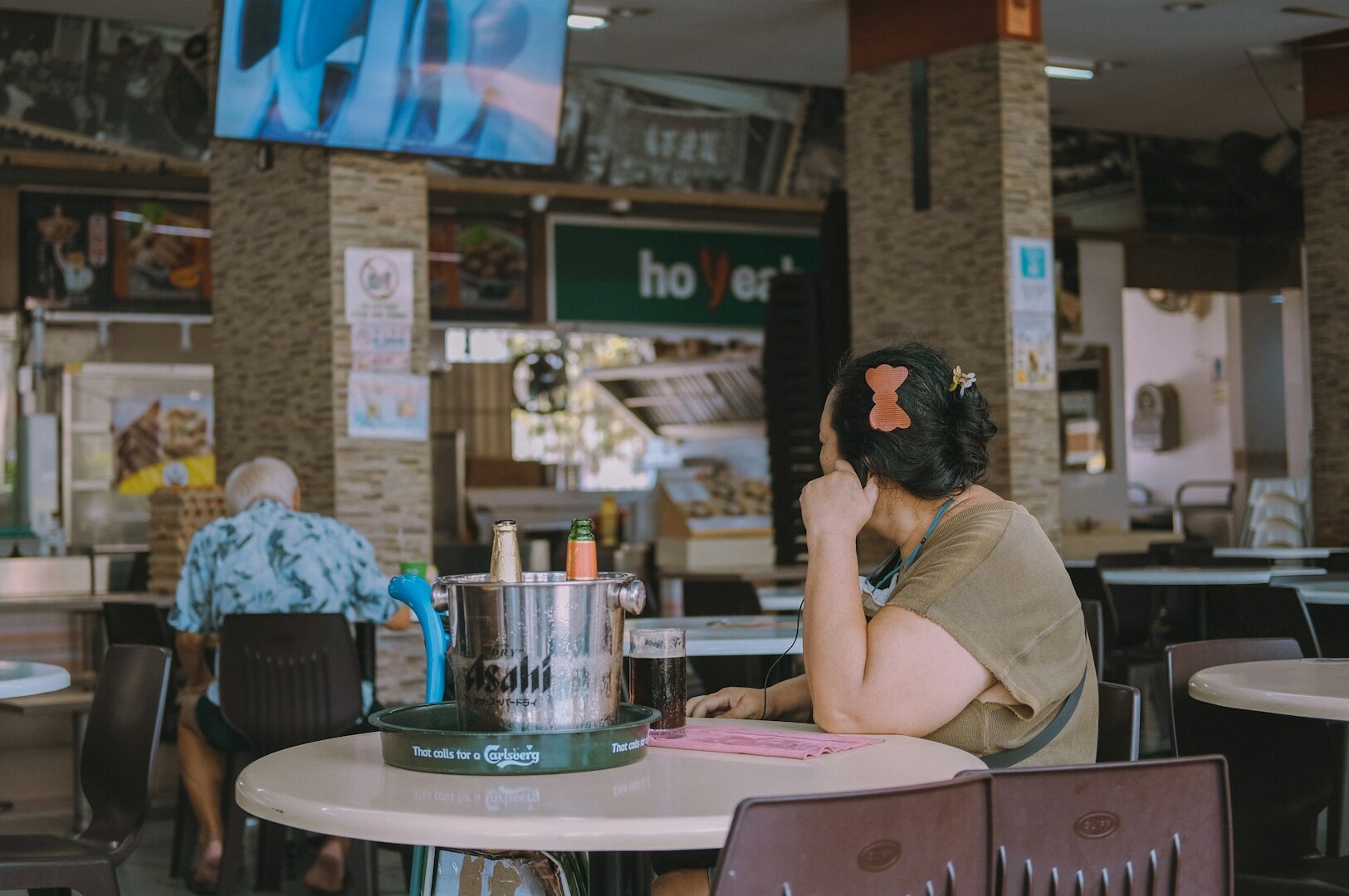 A woman at a table in a tranquil restaurant, highlighting a quiet brunch experience in Singapore.
