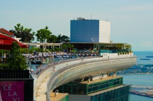 A spacious building with a pool, set against the backdrop of Marina Bay and the Singapore skyline, ideal for fine dining.