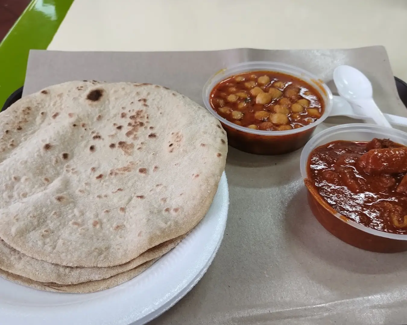 Soft, freshly made chapati with a light golden char, served warm alongside a bowl of savoury curry, highlighting a simple yet satisfying traditional pairing.