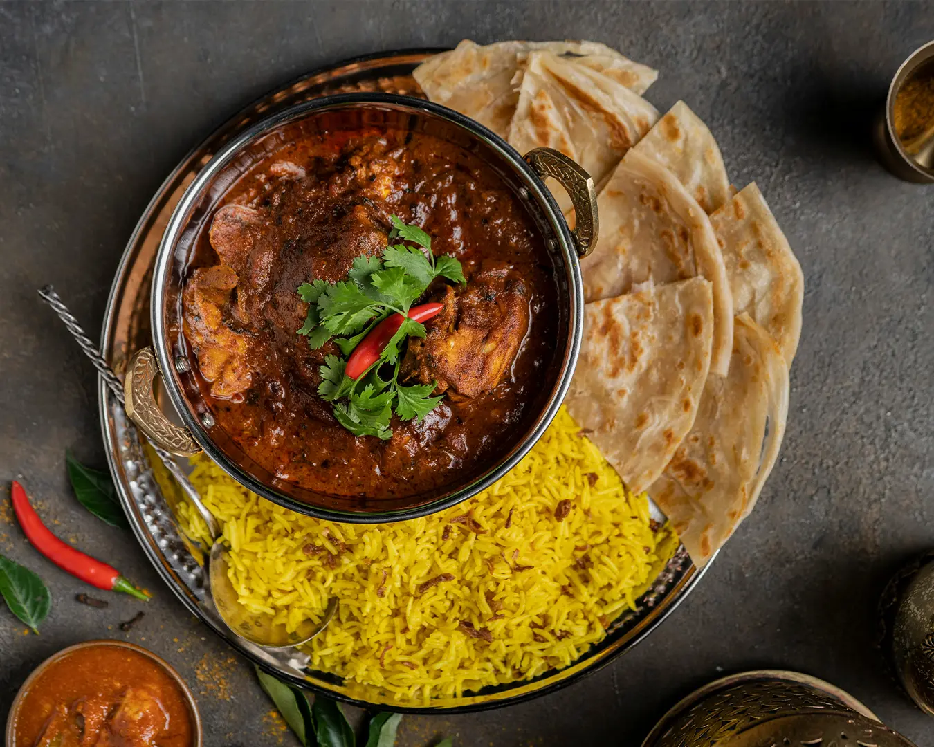 A fragrant serving of biriyani rice, rich with spices and herbs, paired with succulent curry chicken, creating a colourful and flavour-packed dish.