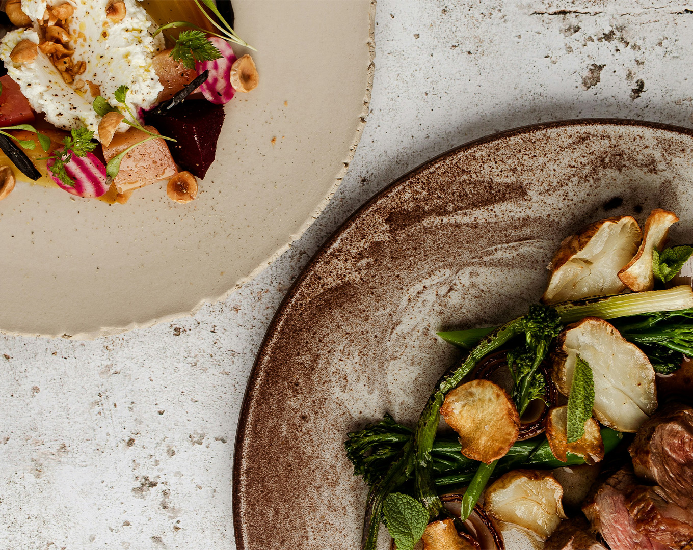 Two elegantly plated fine dining dishes placed side by side, featuring artistic presentation and balanced compositions that emphasise creativity and refinement.