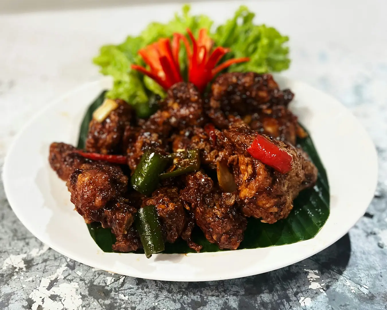 A plate of rich and aromatic rendang, slow-cooked beef coated in thick, dark spices, showcasing one of Southeast Asia’s most flavourful dishes.