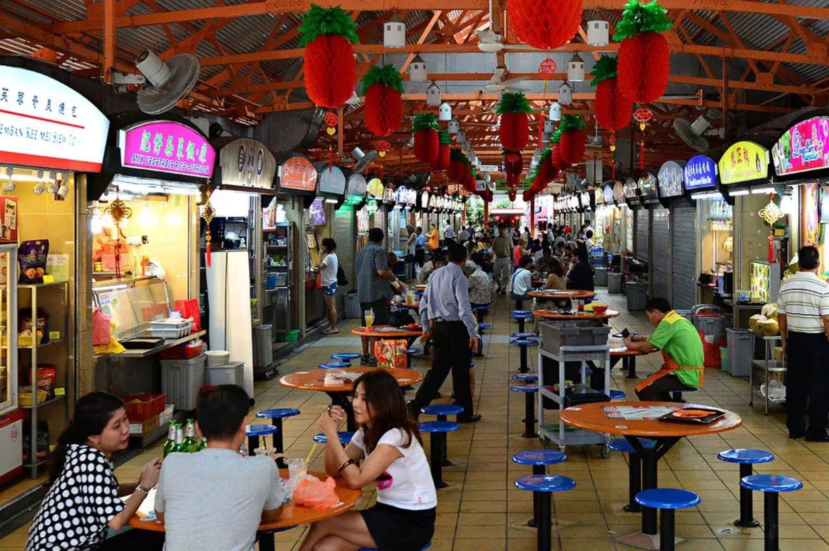 Crowded market scene at Chinatown Food Street, Singapore, with visitors dining and shopping among vibrant stalls.