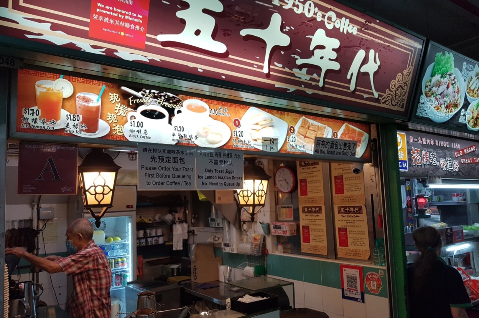 A man poses in front of a restaurant sign on Chinatown Food Street, Singapore, showcasing the vibrant dining scene.
