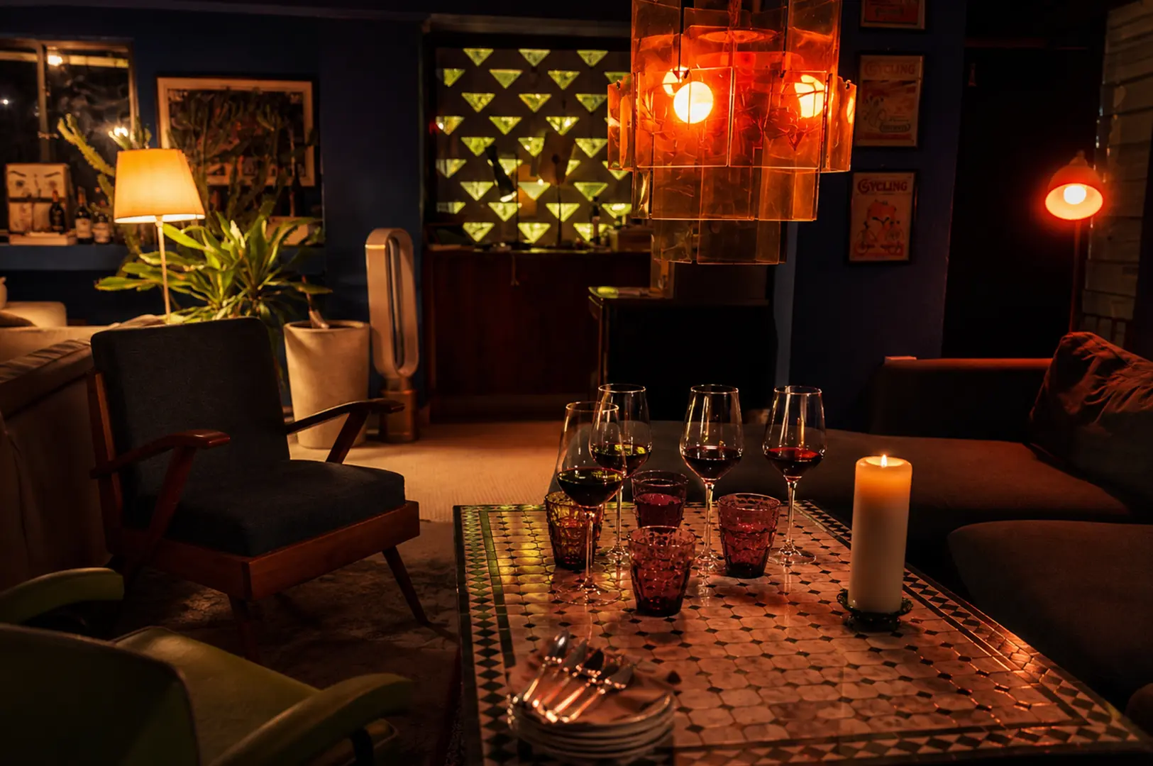 Cozy lounge with candlelit table, wine glasses, and warm ambient lighting for an intimate evening.