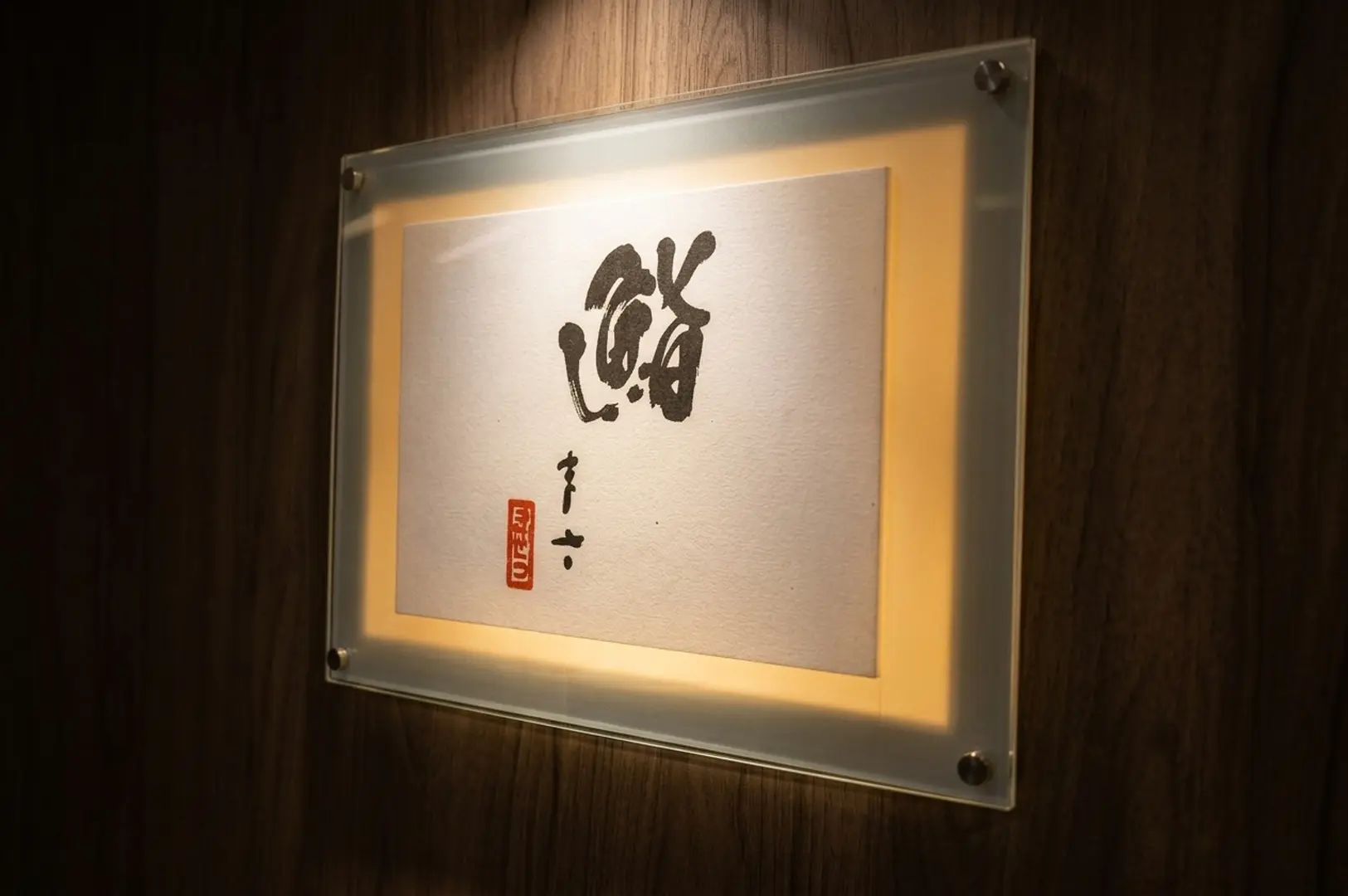 Illuminated wall plaque displaying the Japanese calligraphy logo for Sushi Masa