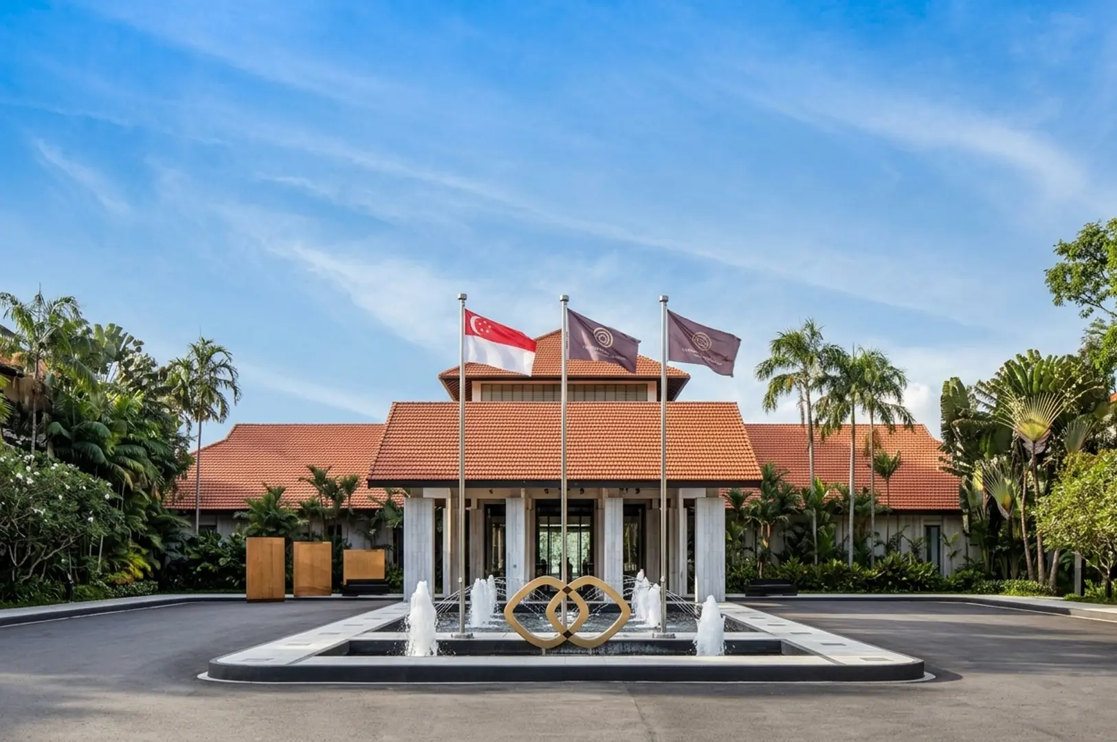 Grand entrance of luxury Sentosa resort with terracotta roof, Singapore flag, and fountain