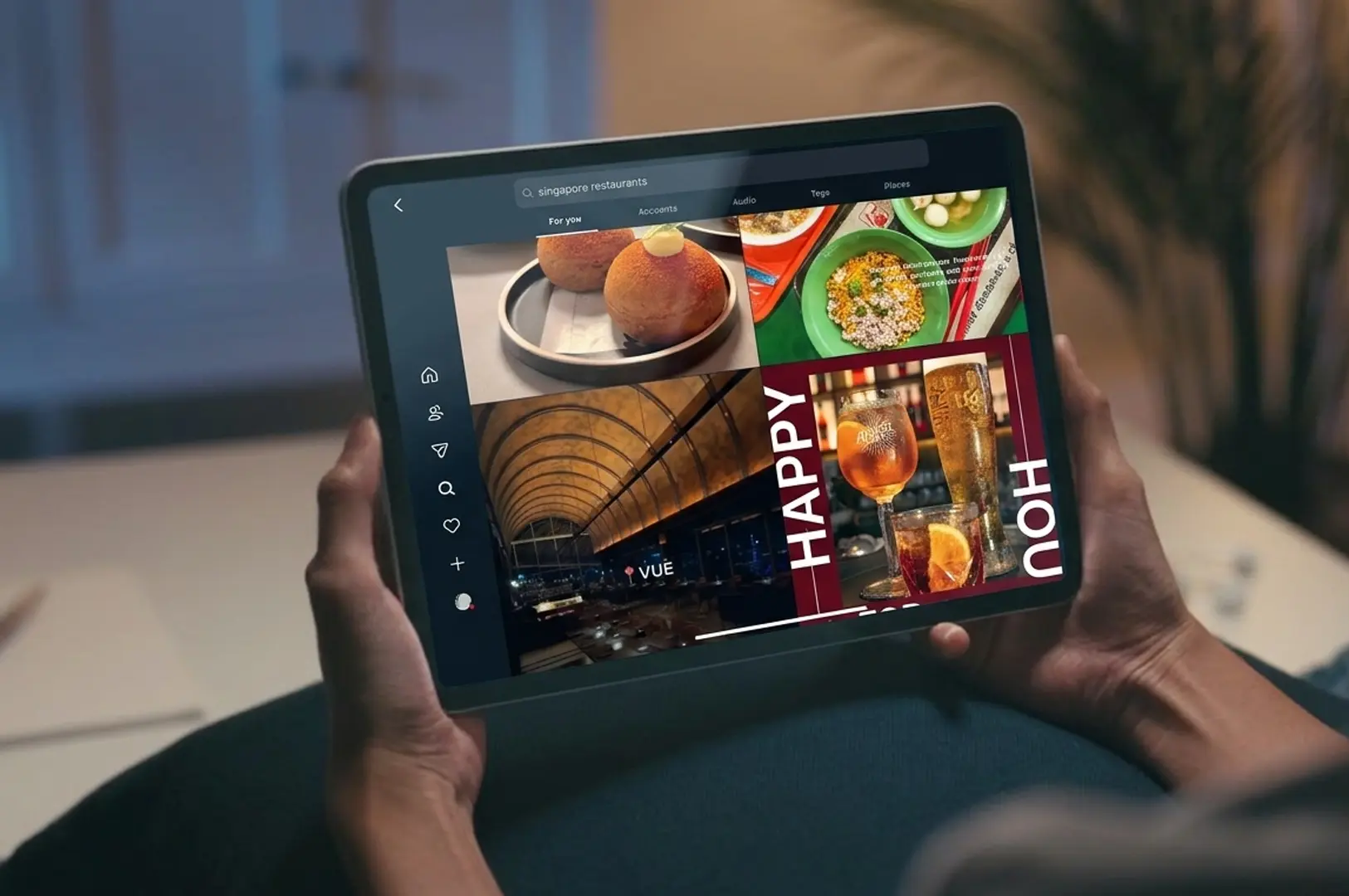 Person holding a tablet browsing Singapore restaurant recommendations and food photos on a social media app