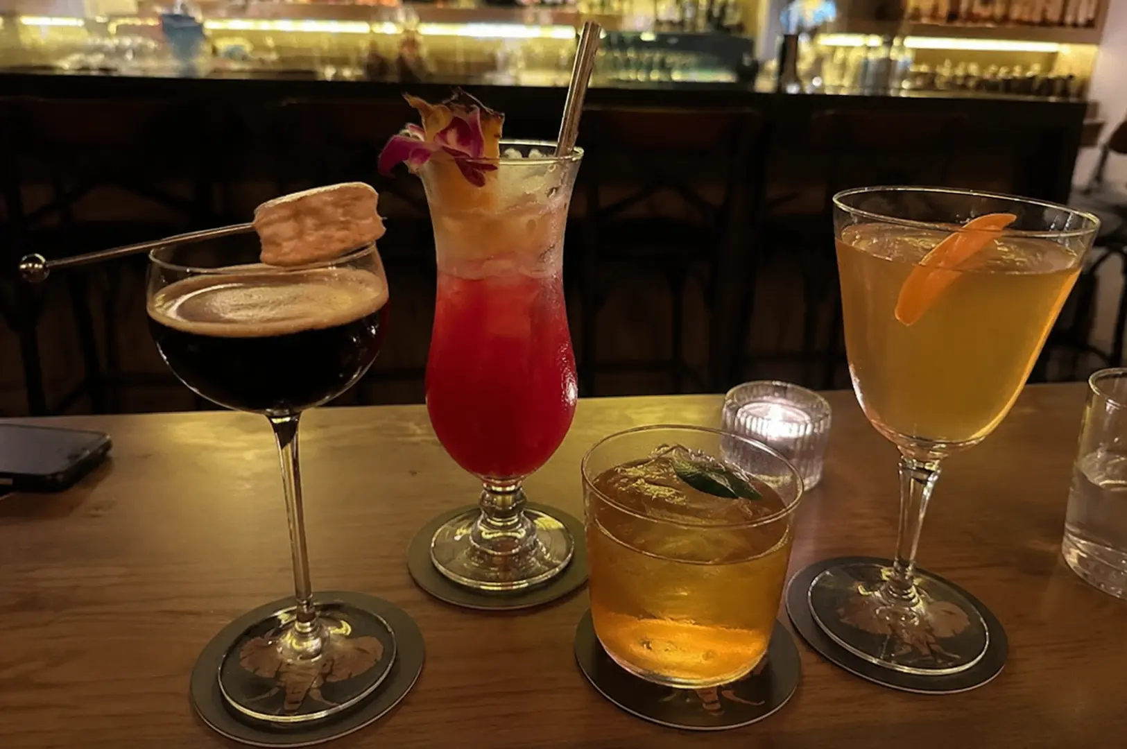 Selection of bespoke cocktails served at a Singapore bar, featuring creative presentations and handcrafted signature drinks