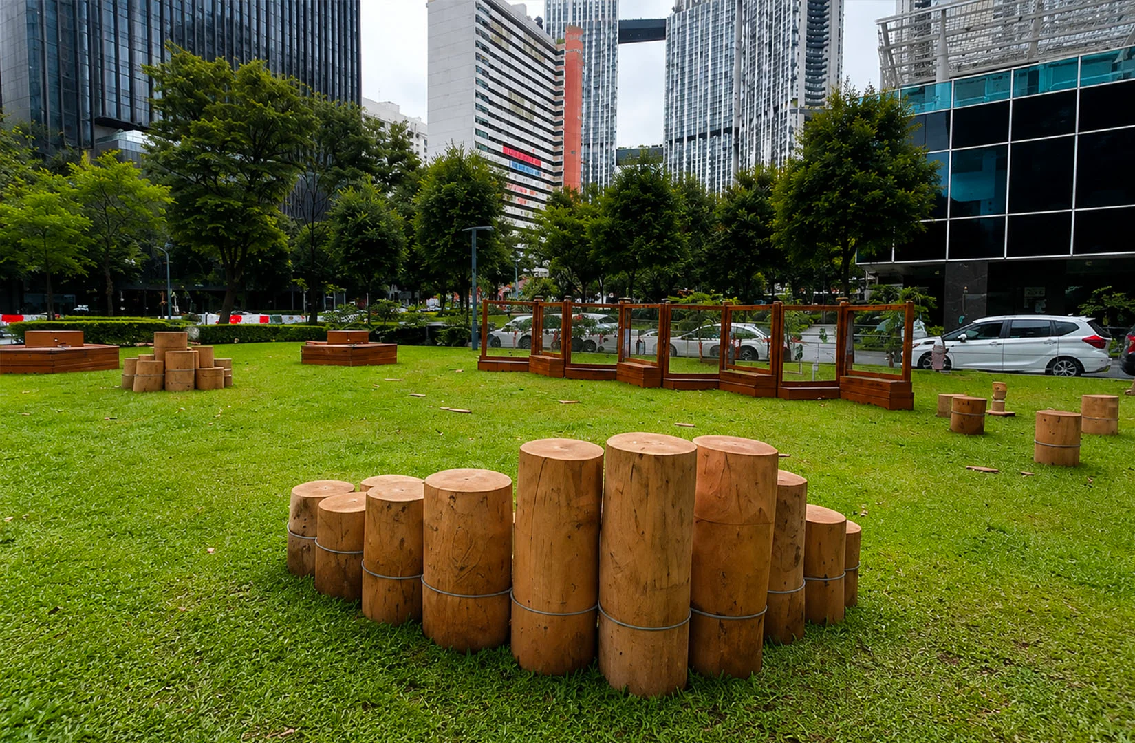 Green lawn and wooden play area at Guoco Tower Urban Park in Tanjong Pagar.