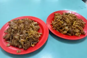Plate of Singapore char kway teow with stir-fried noodles and bean sprouts