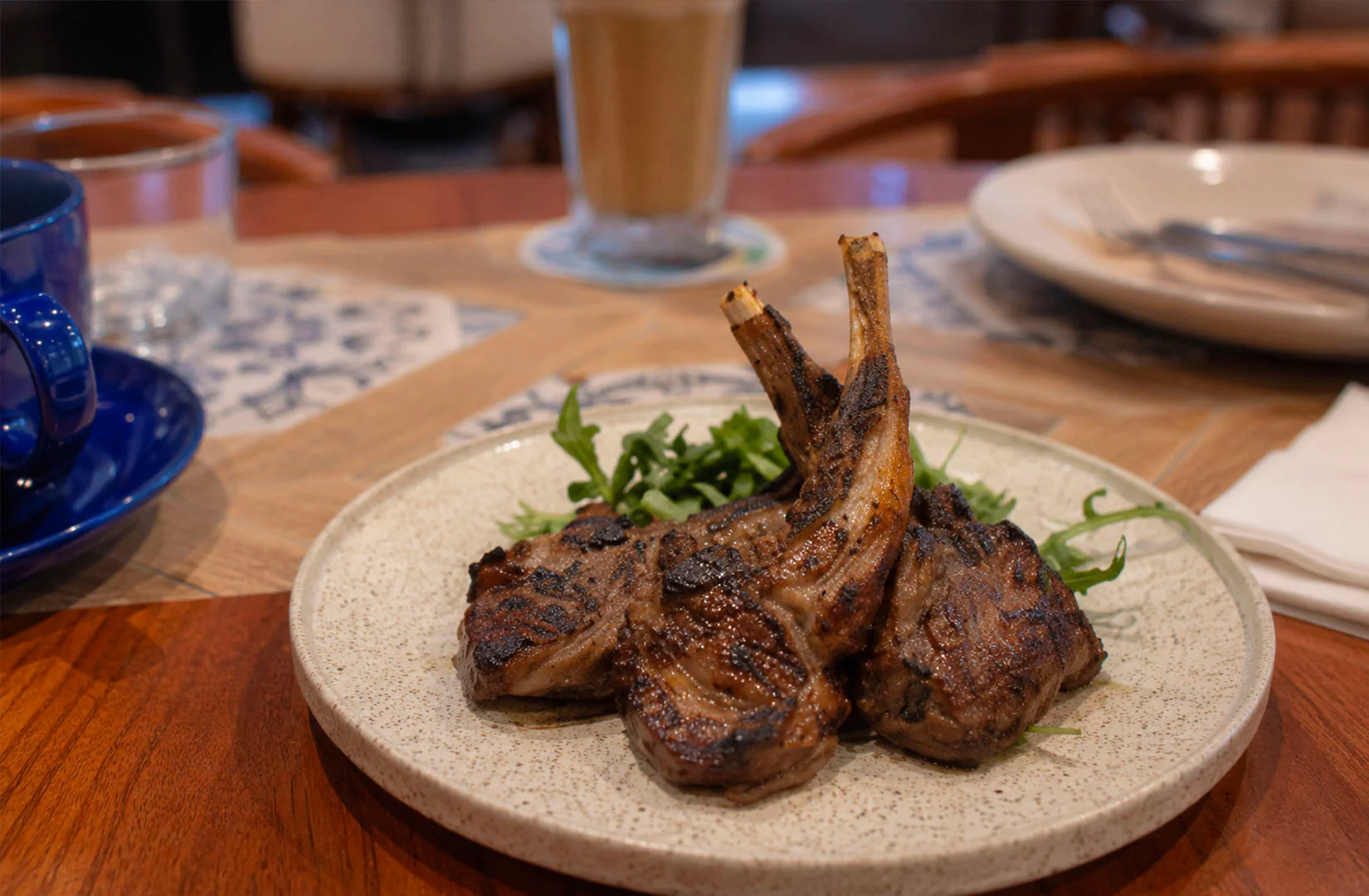 Grilled lamb chops served at Sol & Luna Singapore restaurant with café-style ambiance.