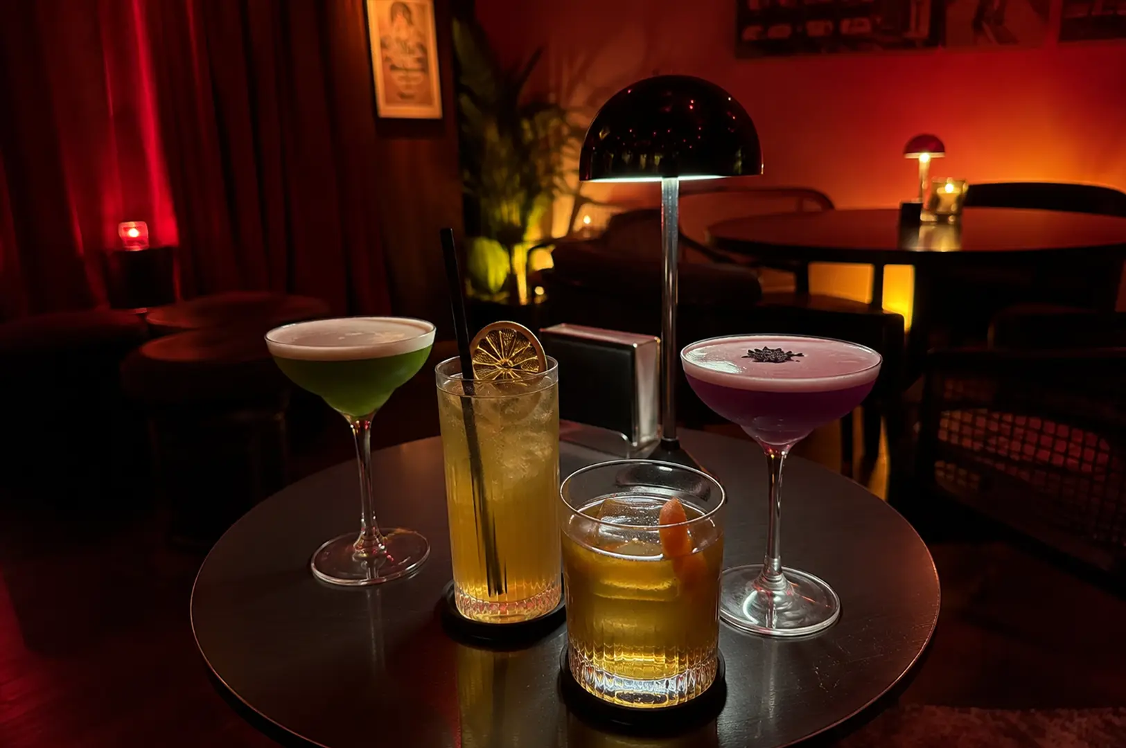 A selection of four handcrafted cocktails arranged on a small table inside APT, highlighting the café's relaxed atmosphere and coffee-meets-cocktail concept.