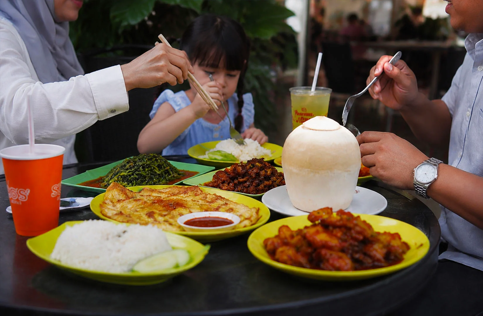 Family enjoying a mix of local and foreign dishes together at a Singapore restaurant, showing how diverse food cultures blend into everyday dining.