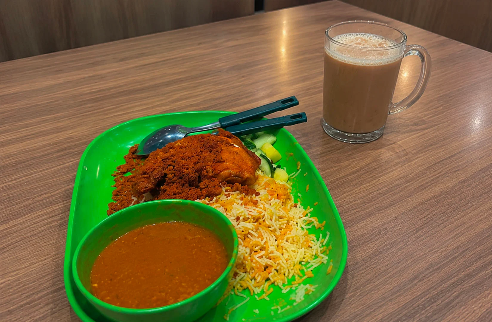 Golden Nur Singapore serving authentic chicken biryani with curry and traditional milk tea.