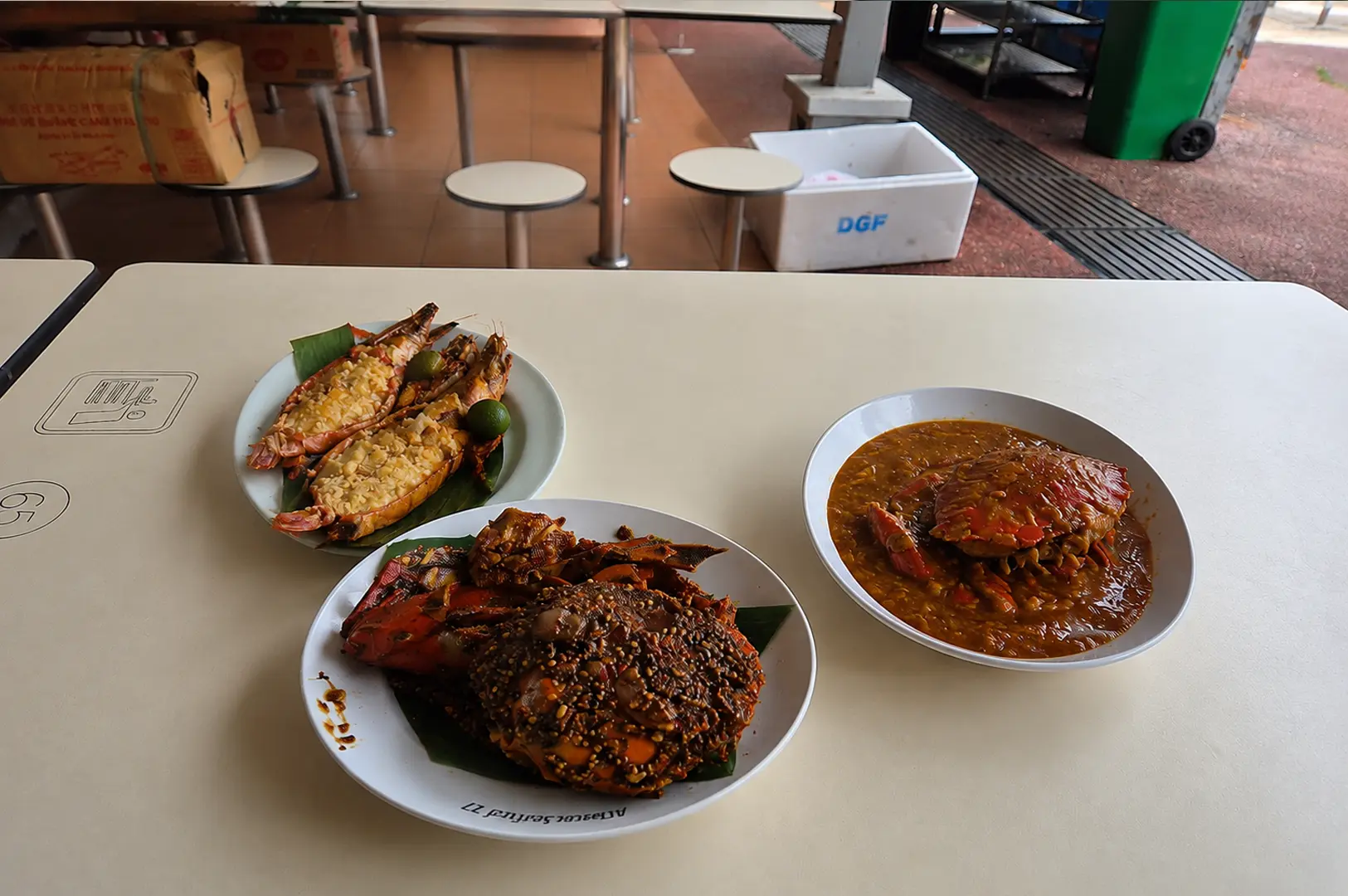 A seafood feast featuring garlic butter prawns, black pepper crab, and a bowl of rich chili crab