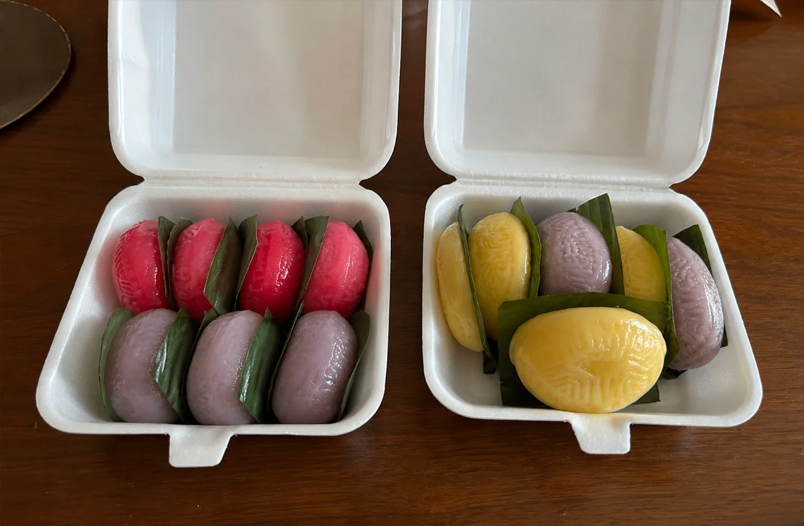 Traditional colorful rice cakes and pastries from Ji Xiang Confectionery arranged in takeaway boxes.