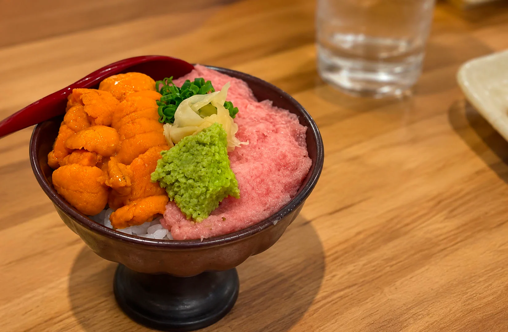 Negitoro and tuna sashimi rice bowl with salmon roe and seaweed salad.