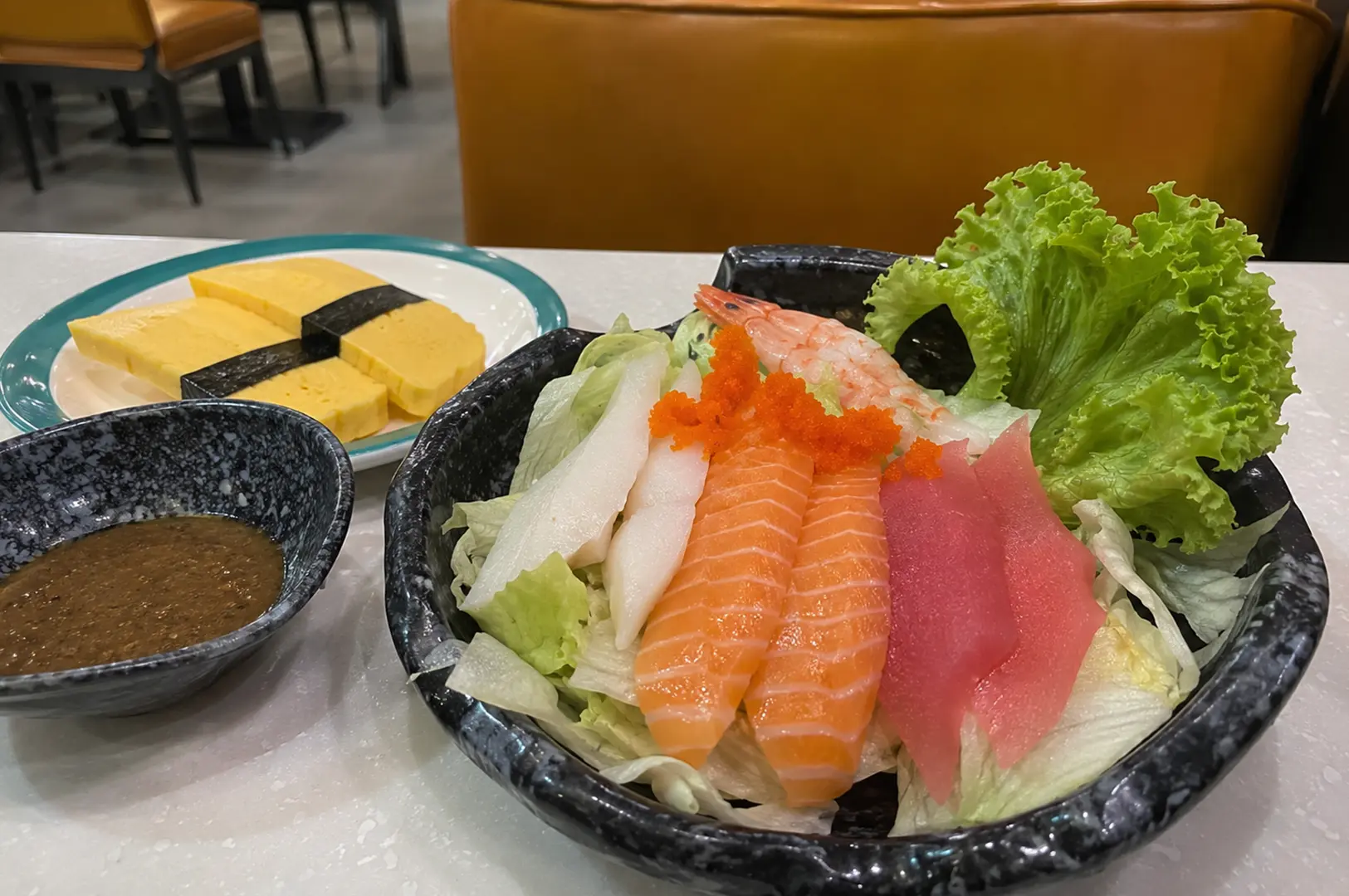 Fresh sashimi salad with salmon, tuna, shrimp, roe, and tamago served with sesame dressing.
