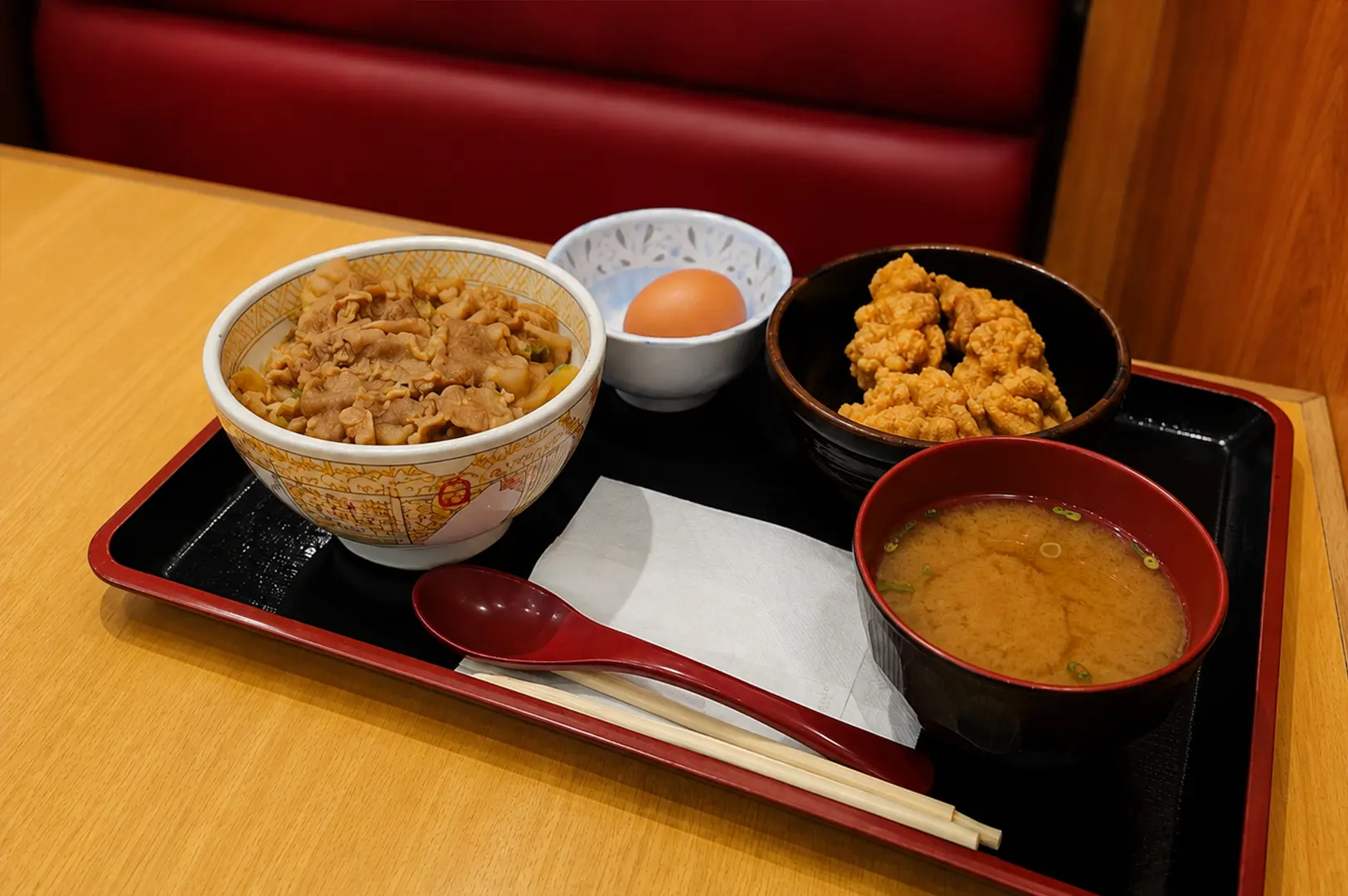 Sukiya gyudon set with miso soup, fried chicken bites, and a fresh raw egg.