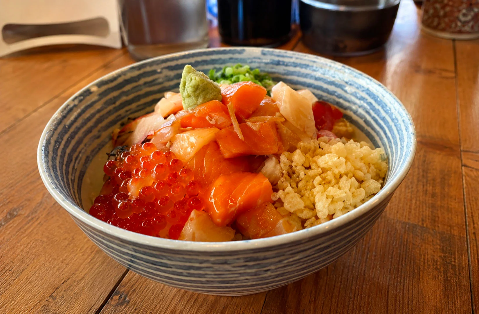 Fresh assorted sashimi rice bowl served with miso soup and salad.