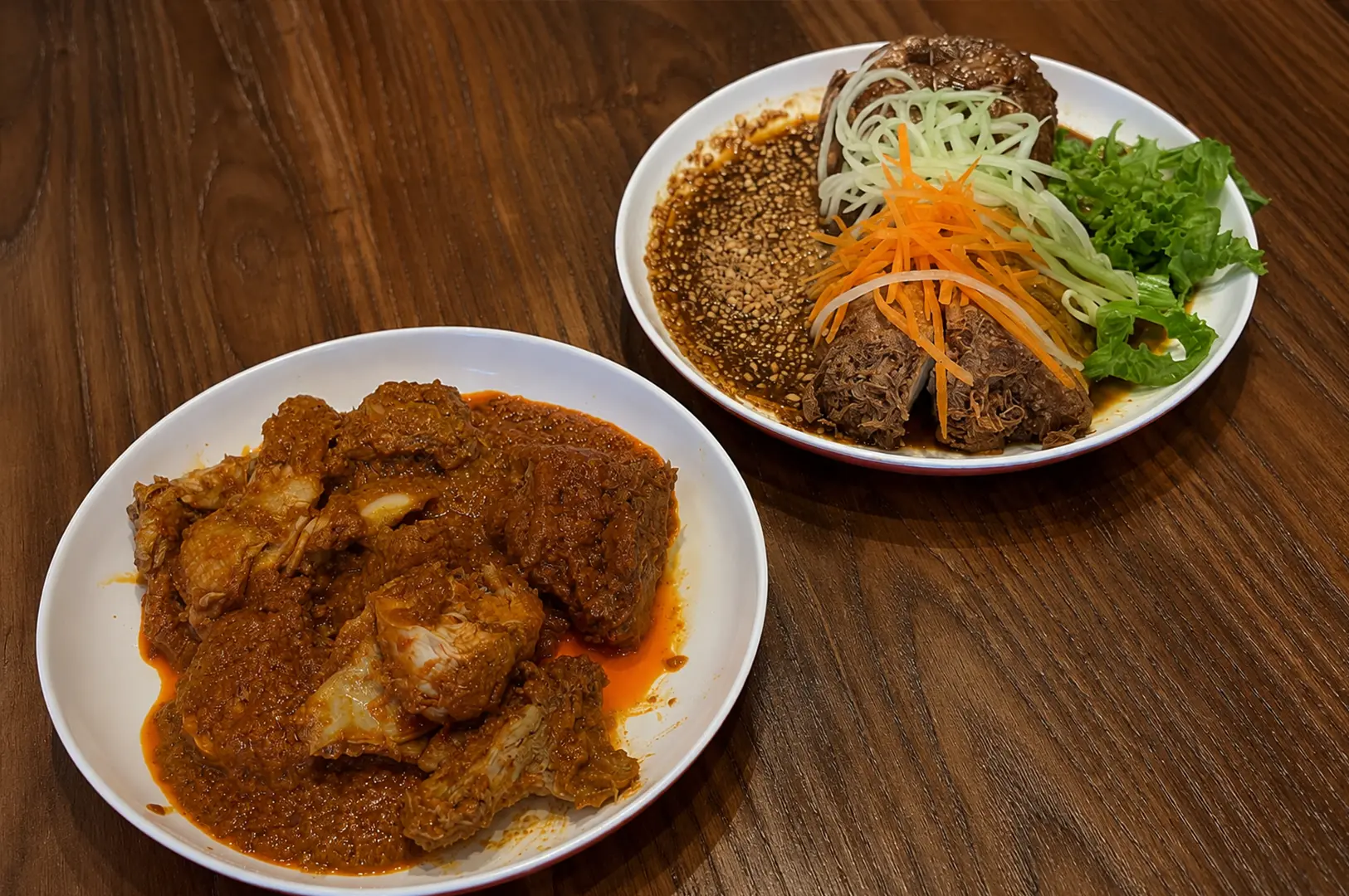 Rumah Makan Minang Nasi Lemak serving spicy chicken and braised beef with fresh vegetables.