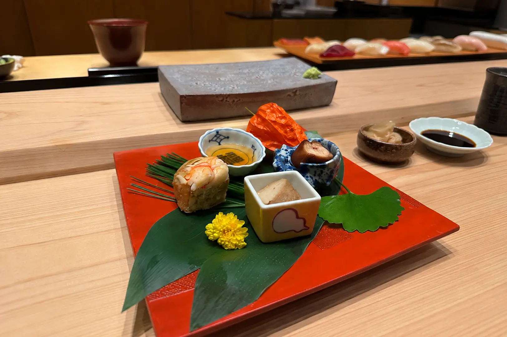 Refined Japanese appetizer platter with seafood, seasonal bites, and decorative presentation.