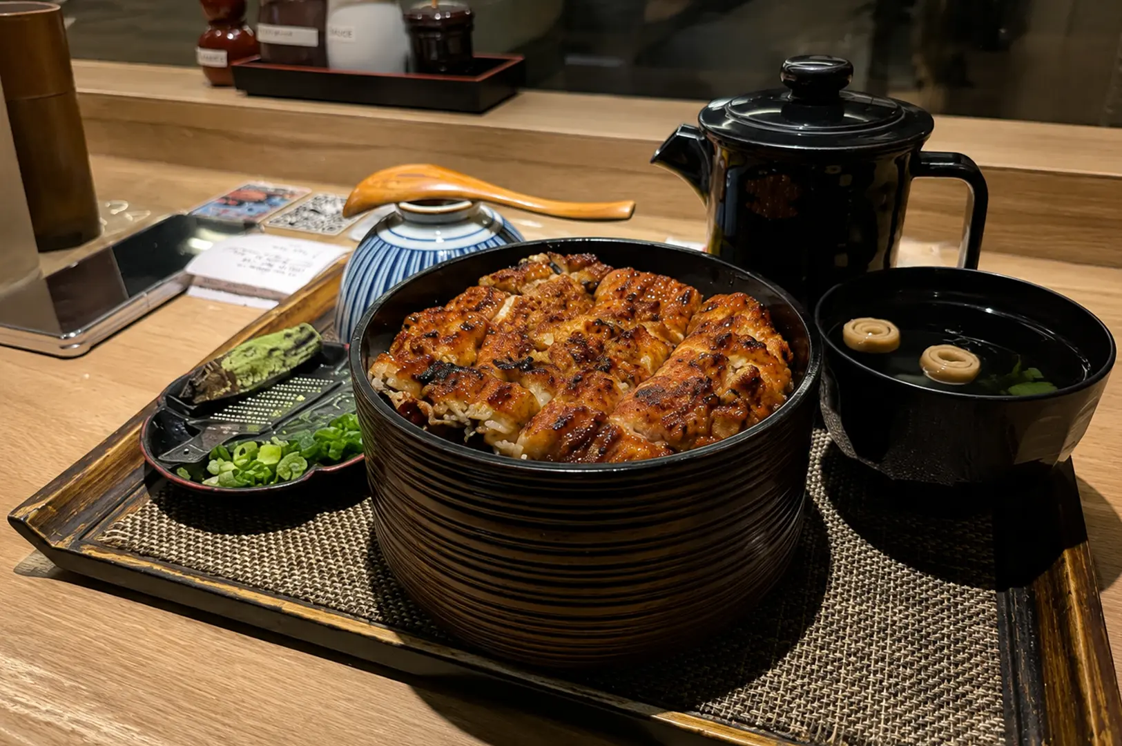 Grilled unagi rice bowl served with miso soup, wasabi, and traditional condiments.