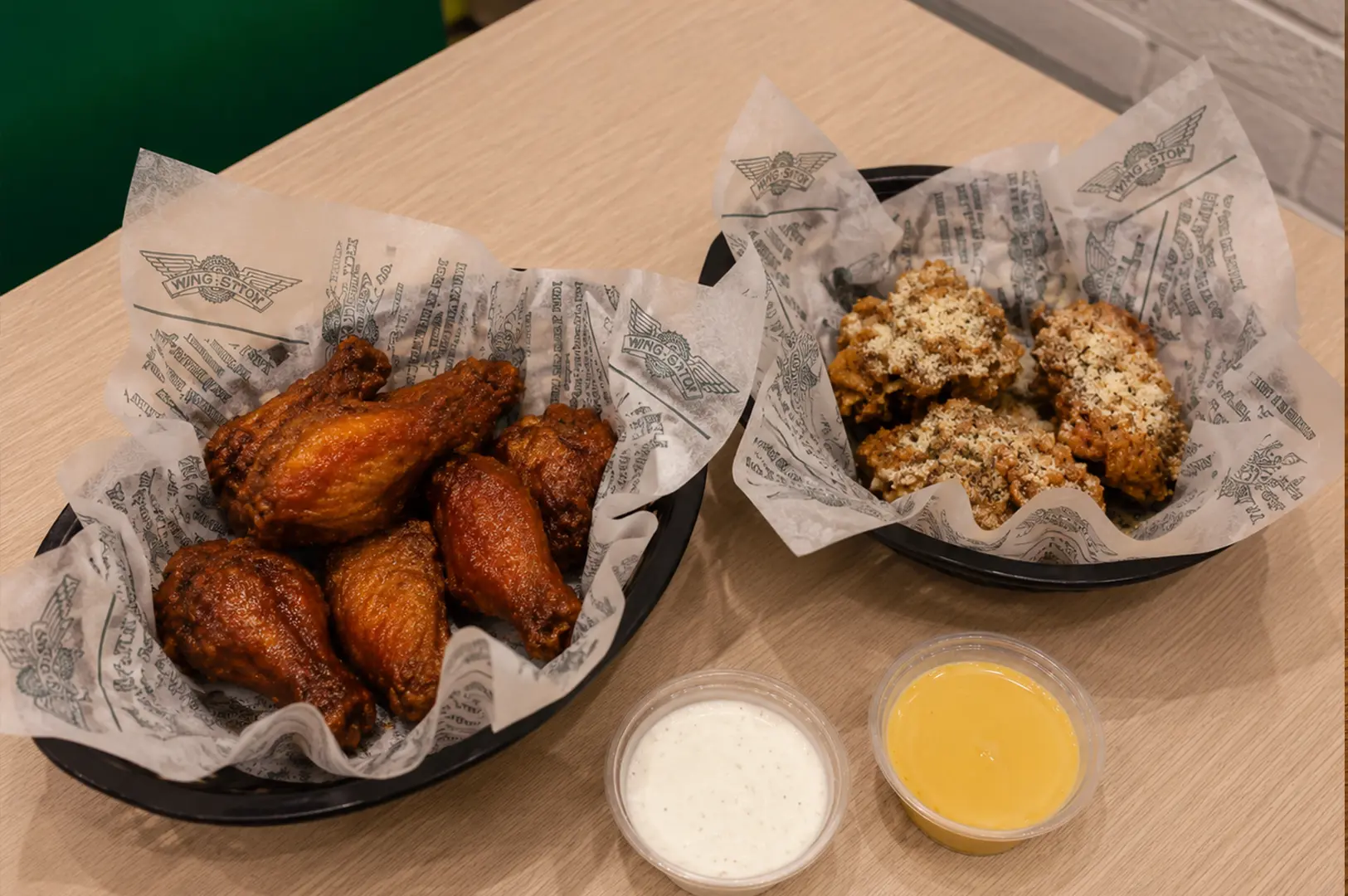 Wingstop chicken wings in different flavors served with creamy dipping sauces.
