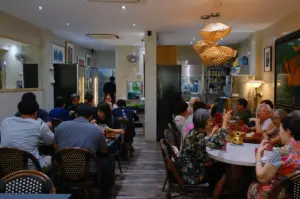 A busy Hup Lok dining room filled with diners, warm lighting, and traditional decor.