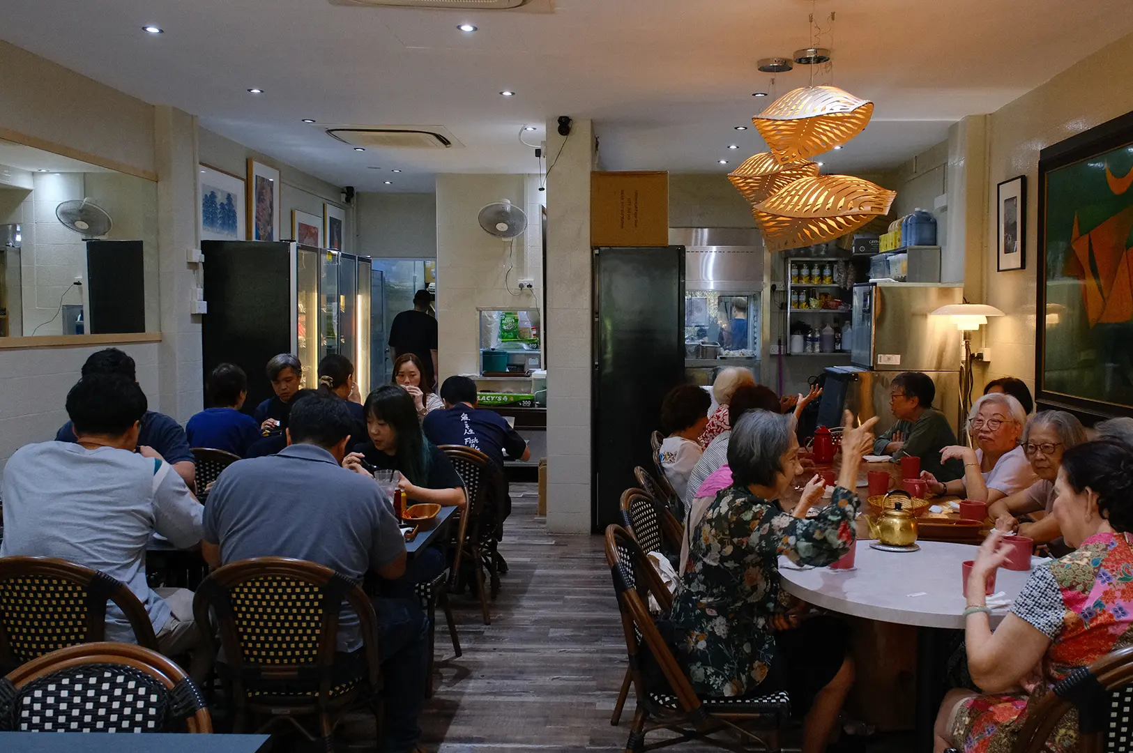 A busy Hup Lok dining room filled with diners, warm lighting, and traditional decor.