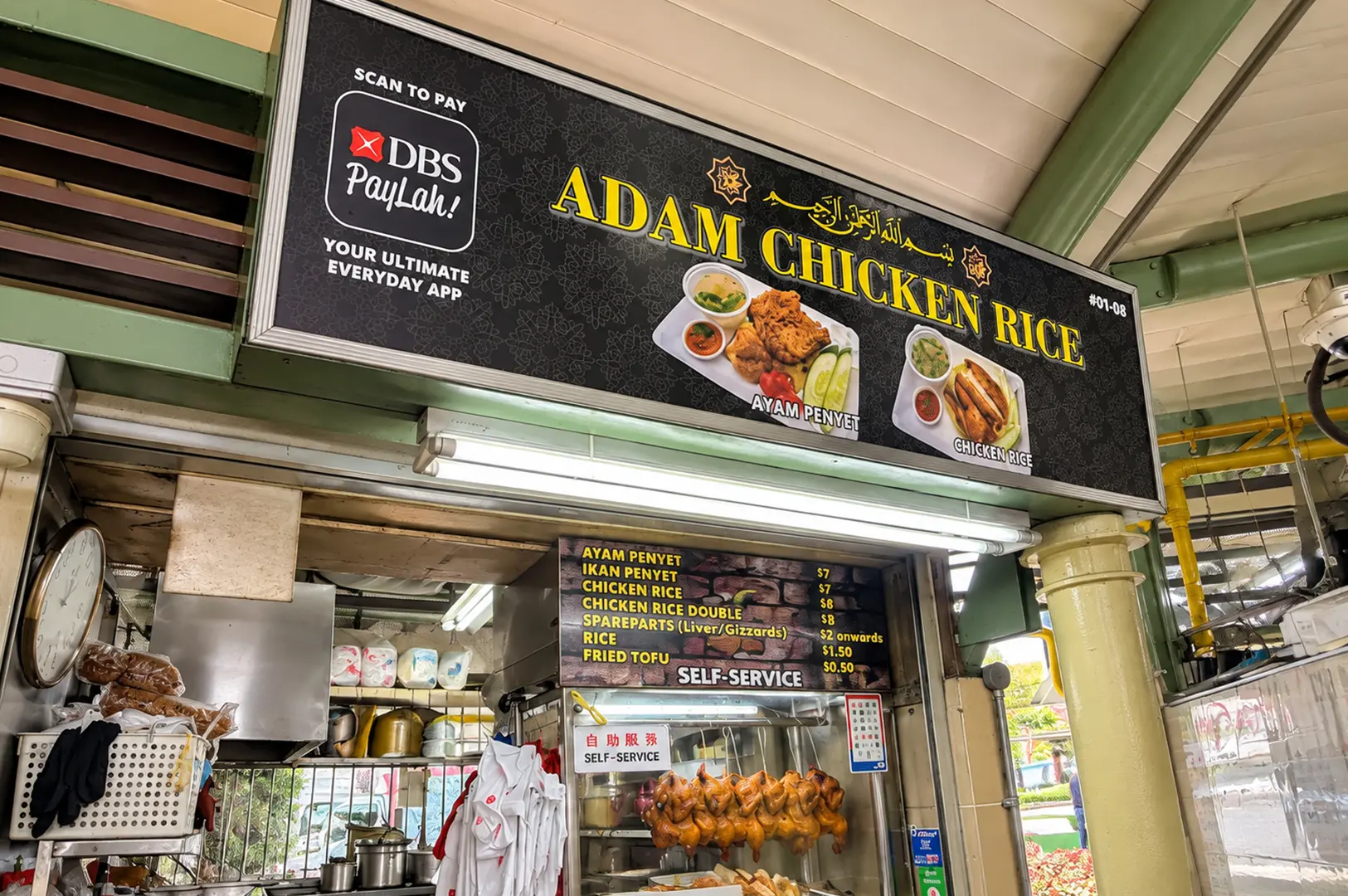 Adam Chicken Rice stall with a menu featuring chicken rice, ayam penyet, liver and gizzard, and fried tofu.