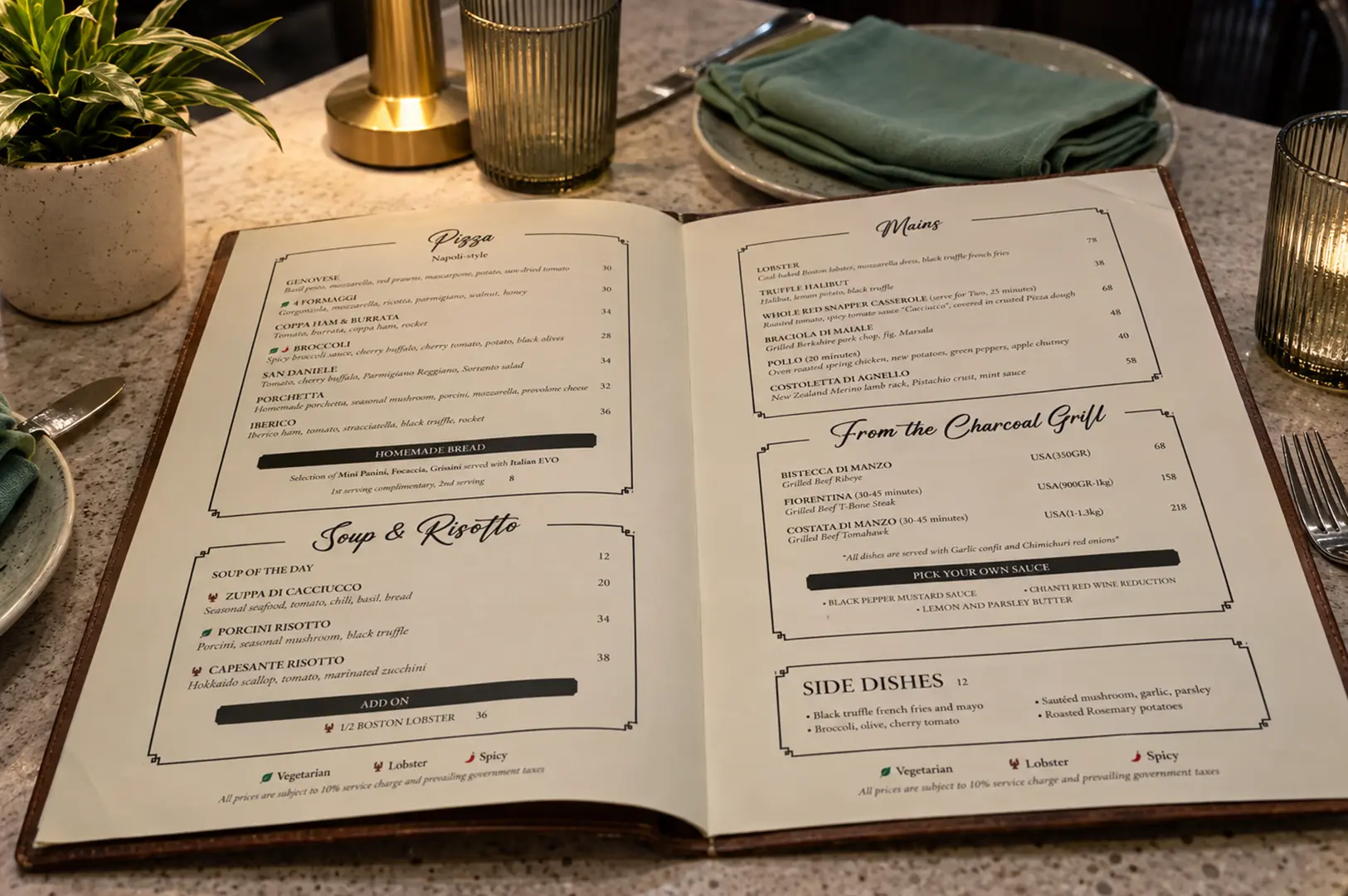 Open restaurant menu displaying pizza, risotto, mains, charcoal-grilled dishes, and side dishes on a dining table.