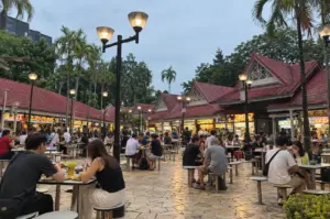 Bustling Singapore hawker centre with diners enjoying meals outdoors at dusk.