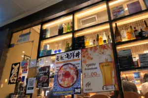 Teppei Japanese Restaurant entrance in Tanjong Pagar, Singapore, with illuminated shelves, Japanese food posters, and a warm interior.