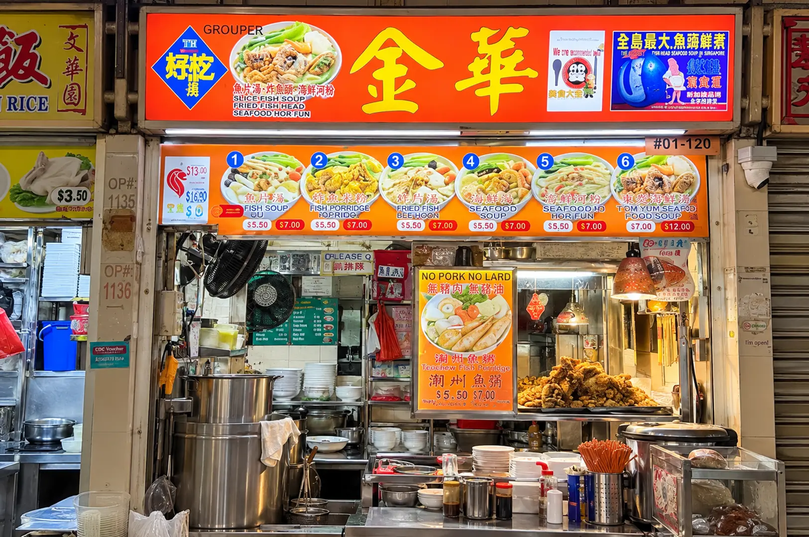 Teochew fish soup stall with colorful menu signs and a busy food preparation counter.