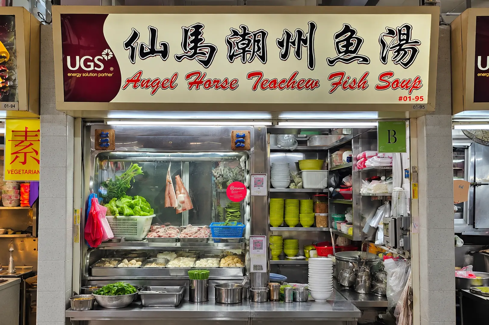 Angel Horse Teochew Fish Soup stall with fresh ingredients, stacked bowls, and an open stainless steel kitchen counter.